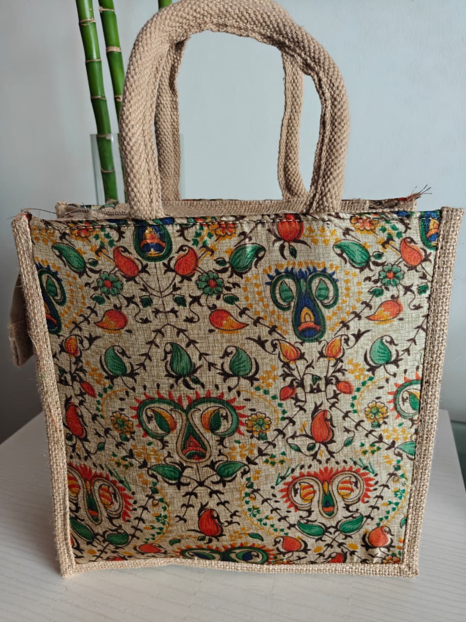 Decorative jute bag with colorful pattern on a light background