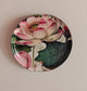 Decorative plate with a pink lotus flower design on a beige background