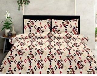 Bedding set with geometric pattern on a bed with a black headboard.