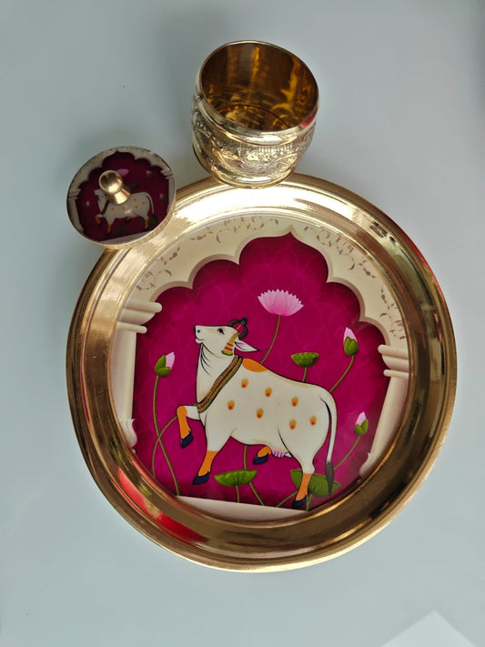 Decorative brass tray with a cow illustration on a pink background