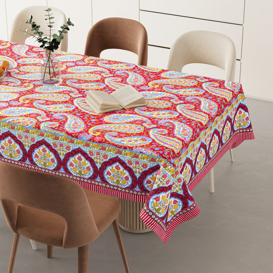 Colorful paisley-patterned tablecloth on a dining table with chairs.