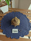 Blue textured placemat with a gold decorative item and 'Sajja' tag on a wooden surface.